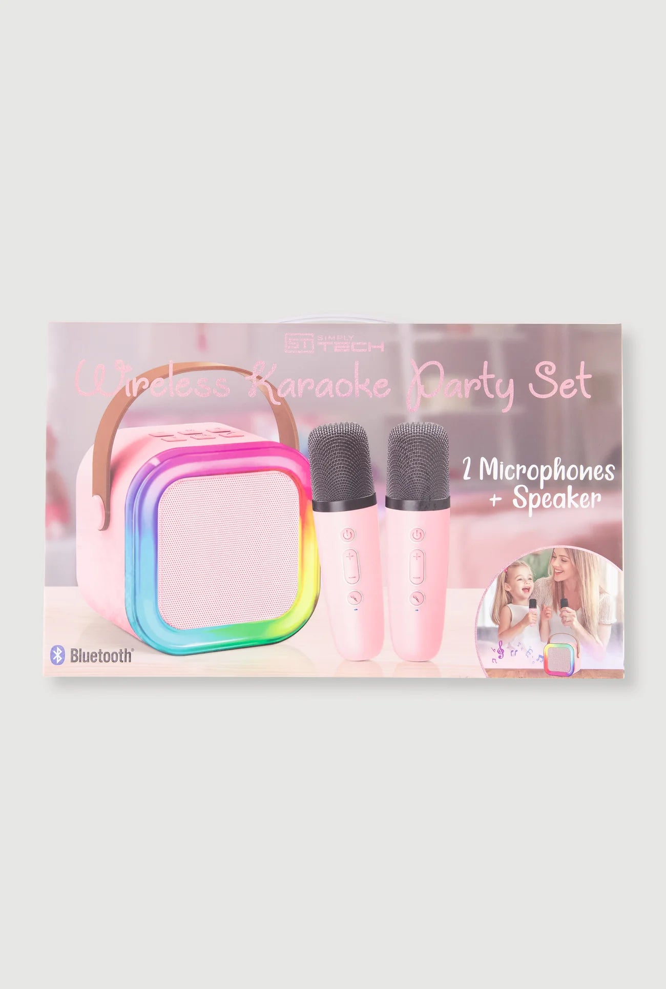 A wireless karaoke party set including a pink portable speaker with a rainbow-colored front border, two pink microphones, and a small circular inset photo, shown on a light gray background.